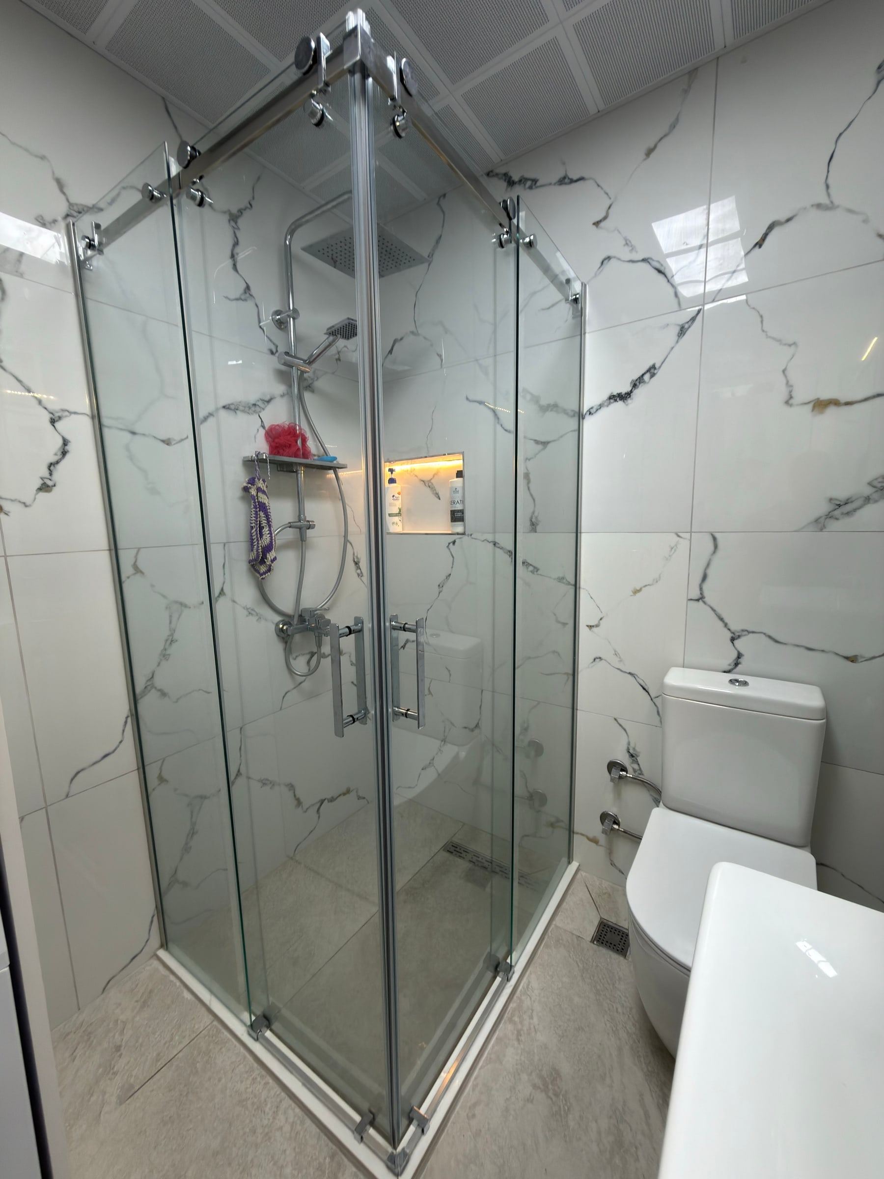 Beyaz mermer görünümlü seramik kaplı banyo ve duşakabin
